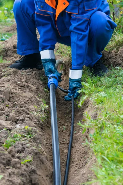 Man Special Clothes Puts Long Black Pipe Water Supply — Stock Photo, Image