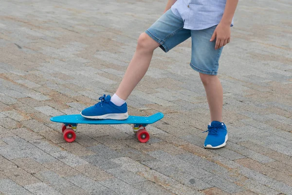 파란색 스케이트 보드에 소년의 아이의 오른쪽 다리의 클로즈업 포장에 — 스톡 사진