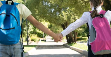 parkta, temiz havada, yakın çekim, el ele tutuşan öğrenciler, arka görüş