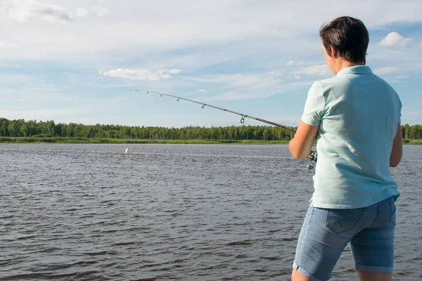 クローズアップ 美しい湖と青空を背景に女性 釣り竿で釣り 背面図 — ストック写真