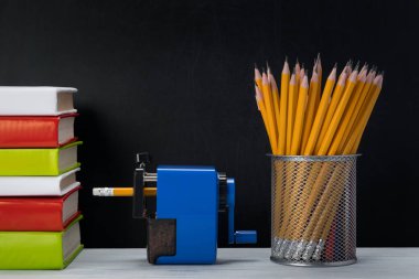 karanlık bir arka plan tablosunda kitap ve kalem yığını