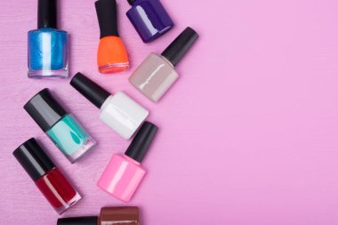 pembe bir arka plan üzerinde çok renkli tırnak cilaları, yazıt için bir yer