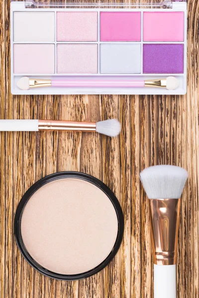 set of palette eyeshadow and blush on a wooden table