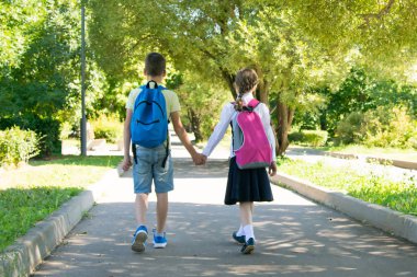 parkta, temiz havada, okul çocukları el ele tutuşuyor, arka görüş