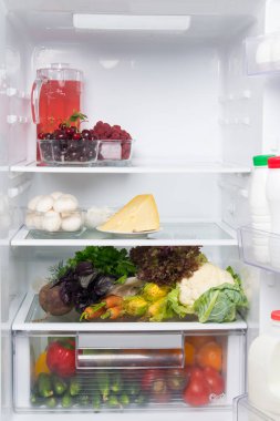 beyaz buzdolabı raflarında, gıda stok, taze sebze, çilek, peynir, mantar, süzme peynir, bir sürahi komposto ve kapı süt ürünleri, kefir, krem