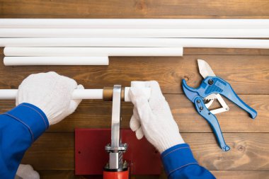 eller ahşap bir zemin üzerinde plastik su boruları bağlamak