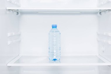 yakın çekim, beyaz buzdolabı rafları ve bir şişe su