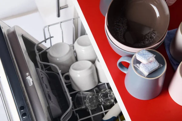 yağ dan temizlik için iki kapsül, bulaşık makinesiiçine yüklemeden önce, masanın üzerinde, kirli tabaklar üzerinde yalan