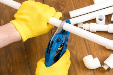 sarı eldiven ustasının elleri beyaz boru bir parça kesti, yakın çekim