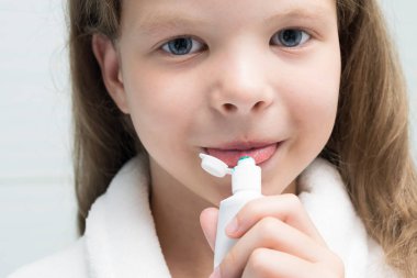 küçük kız beyaz diş macunu yiyor, closeup görünümü