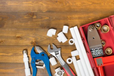 ahşap bir arka plan üzerinde su boruları montajı için nesneler ve araçlar kümesi