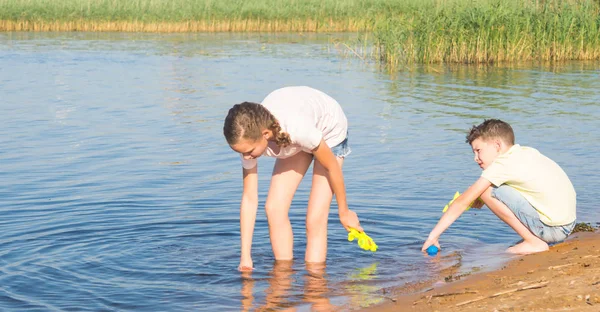 Flicka Och Pojke Samla Vatten Från Sjö Vattenkanoner Att Spela — Stockfoto