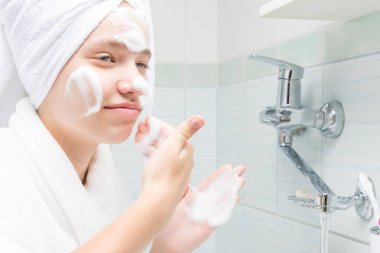 kız bir banyo aynaönünde durur akne ve siyah nokta yüzünü yıkar