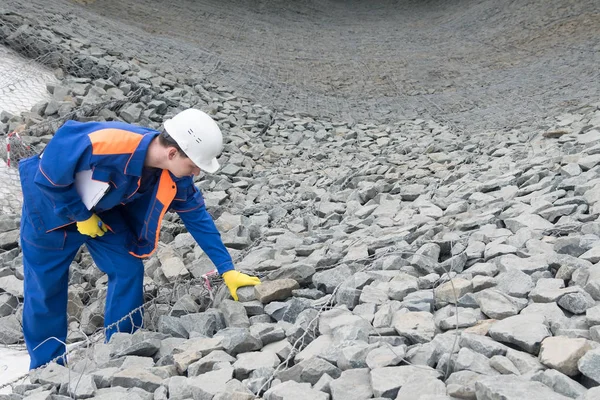 özel giyim bir işçi bir şantiyede taşların kalitesini kontrol eder