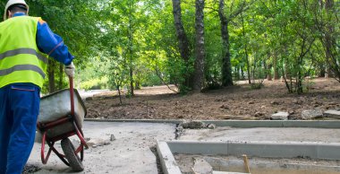 mavi üniformalı bir işçi, bir tramvay taşıyan, arka görünüm, sağda yazıt için bir yer var