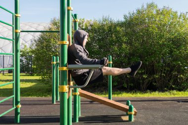 sokakta bir spor zemin üzerinde abs egzersizleri yapan bir adamın yan görünümü