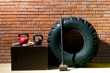 turuncu bir tuğla arka plan karşı, çapraz-fit, siyah lastik, bir çekiç, bir ip ve ağırlıkları yapmak için nesneler vardır
