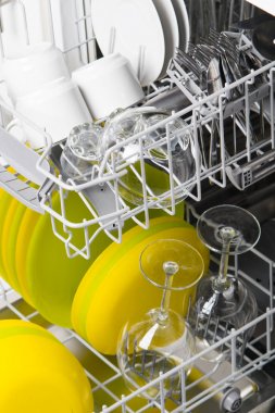 ekonomik bir bulaşık makinesinde yıkandıktan sonra temiz tabak, bardak ve bardak ile iki yükleme ağları