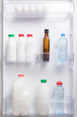 buzdolabının kapısında süt ve su şişeleri var.