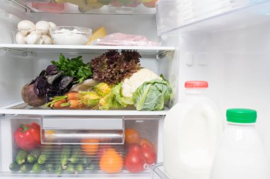 raflarda çeşitli yiyecek ve içecekler ile açık buzdolabı, yakın çekim