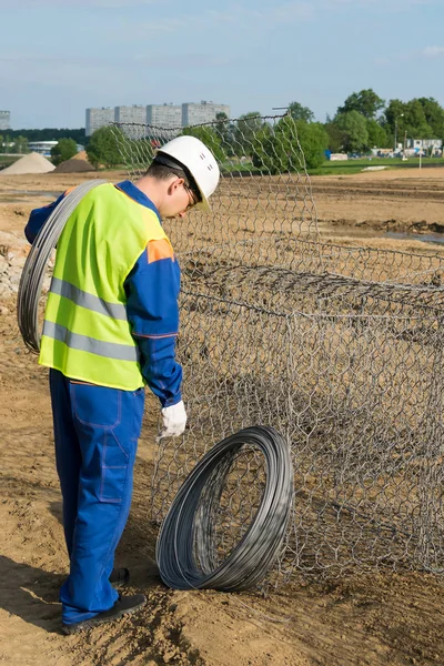 Pracownik Specjalnej Kamizelce Placu Budowy Zajmuje Wiązkę Drutu Pracy Fundamentem — Zdjęcie stockowe