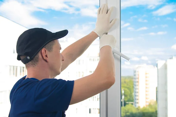 Pracownik Niebieskim Mundurze Dostosowuje Otwór Plastikowego Okna Nieba — Zdjęcie stockowe