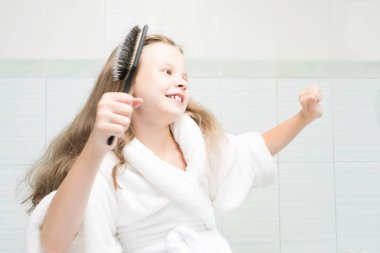 banyoda beyaz ceketli kız dans ve saçlarını tarama