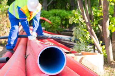 bir boru deliğinin yakın çekim, ölçüm için metre bir işçinin arka plan karşı, üstüne sabitlenir