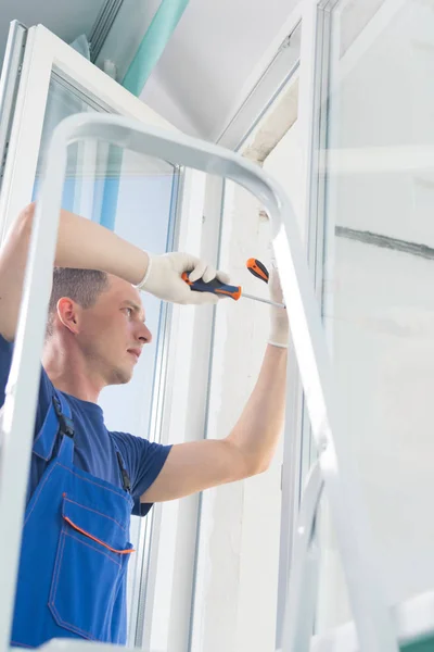 Trabajador Ajusta Ventana Plástico Mientras Está Pie Las Escaleras —  Fotos de Stock