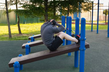 Sabah sokak sporları sahasında karın kası egzersizi yapan bir sporcu.