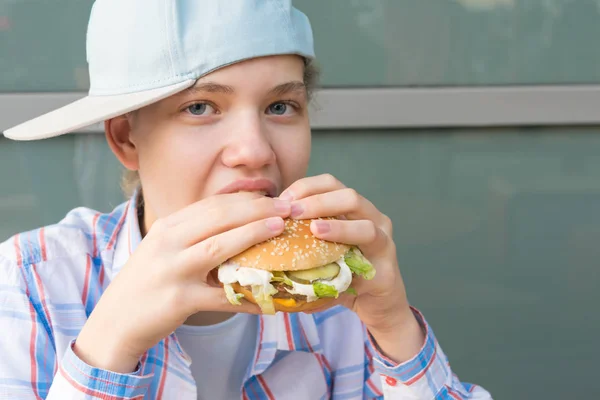Mädchen Mit Baseballmütze Isst Hamburger Mit Fleisch Frontansicht Nahaufnahme — Stockfoto