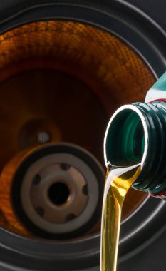 Motor yağı şişeden bir arabanın parlayan hava filtresine doğru akar.