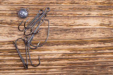 Koyu bir ahşap arka planda, oltalar için bir dizi kanca, sağda yazıtlar için bir yer var.