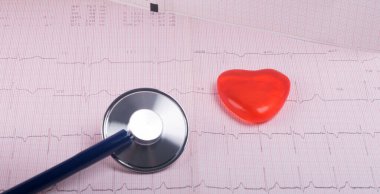 Kardiyogram, fonoskop ve küçük kırmızı bir kalbin arka planına yakın plan.