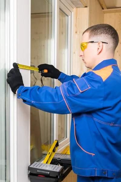 Hombre Ropa Construcción Mide Pared Entre Las Ventanas Con Sus — Foto de Stock