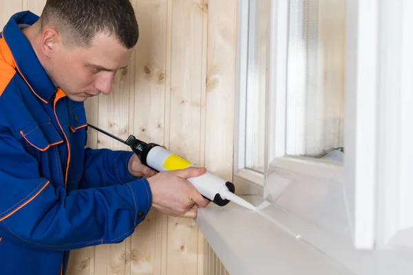 Ein Mann Reparaturkleidung Versiegelt Die Fensterrisse Mit Selikon — Stockfoto