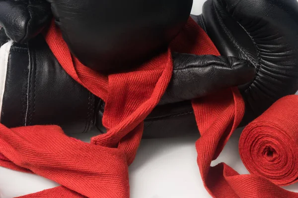 手のための黒のボクシングの手袋と赤の保護包帯の光の背景に クローズアップ — ストック写真