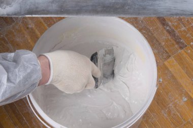 Beton duvarlar için son macunu olan bir kovanın yakın çekimi.