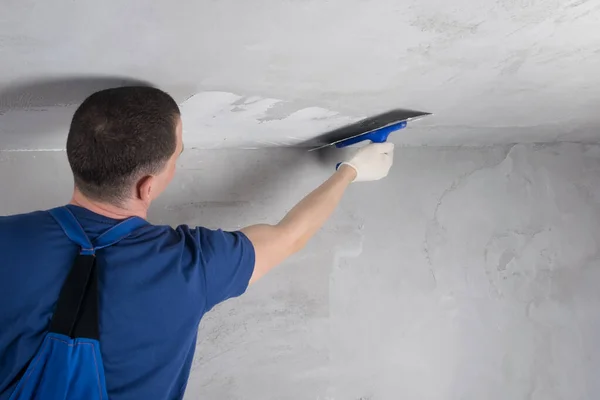 Man doing the alignment of the concrete ceiling, rear view — Stock Image Man Doing Alignment Concrete Ceiling Rear View Stock Picture