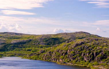 Murmansk bölgesinde, dağlar ve tepeler küçük görünüyor, bu hiçbir kişi veya araba eteklerinde ise. Dağların gövdesinden büyük taşlar çıkıntı, yüzyıllar boyunca tüm rüzgarlar tarafından üflenir. Nazik Barents denizi tepenin eteklerine dokunur..