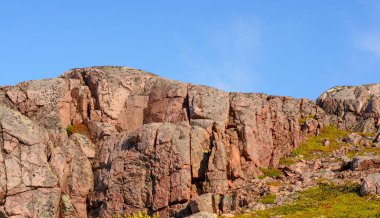 Yeşil ot ve yosun ile çevrili pembe renkli dağ veya tepe. Kuzey enlem parlak renkleri ve düşük masmavi gökyüzü ile ünlüdür. Yaylada bir sürü taş var..
