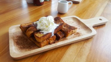 Ahşap plaka üzerinde tarçınlı şeker çikolata ve vanilya yumurtalı ekmek