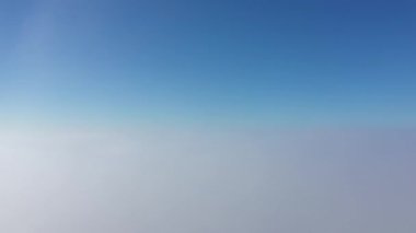 Aşağıdaki sisli bulutlardan yukarıdaki maviyi temizlemek için yumuşak bir eğimle, barışı, sadeliği ve atmosferik güzelliği çağrıştıran minimalist bir gökyüzü görüntüsü..