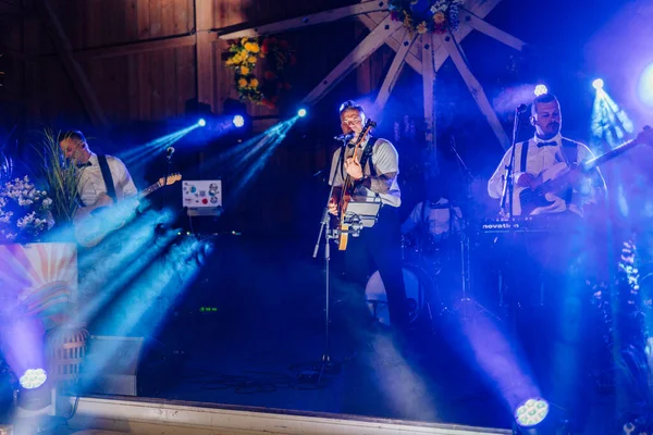 Sigulda, Letonya - 18 Temmuz 2025 - Bir Hippi festivali sırasında renkli ışıklar ve sis efektleri altında canlı performans sergilediler..