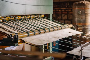 Valmiera, Letonya - 10 Eylül 2025 - Bir marangoz fabrikasındaki patenli taşıma sisteminde hareket eden kaplama kaplaması, endüstriyel işleme ekipmanları ve malzeme işleme.