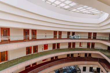 Kemer, Tureky - Eylül 18, 2025 - Çok katlı modern bir otel odasının iç manzarası, sıralı kapılar, cam korkuluklar ve tavan penceresi. Oda servisi en üst katta görünüyor..