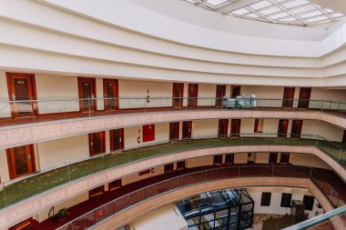 Kemer, Tureky - Eylül 18, 2025 - Çok katlı modern bir otel odasının iç manzarası, sıralı kapılar, cam korkuluklar ve tavan penceresi. Oda servisi en üst katta görünüyor..