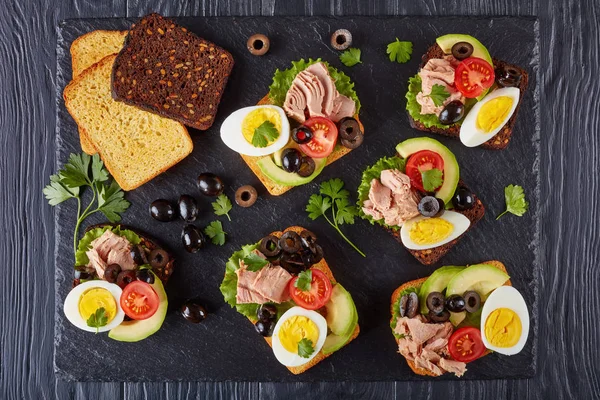Бутерброды Тунцом Ломтиками Авокадо Салатом Помидорами Черными Оливками Варёным Яйцом — стоковое фото