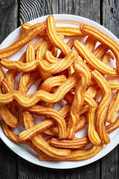 Churros-traditionell spansk efterrätt på en tallrik — Stockfoto