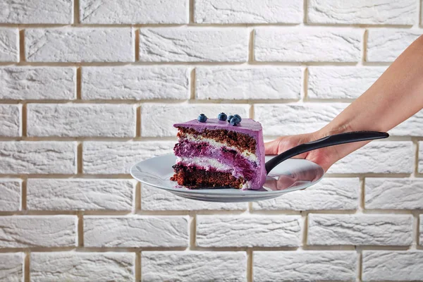 Una mano de mujer sosteniendo una porción de pastel —  Fotos de Stock